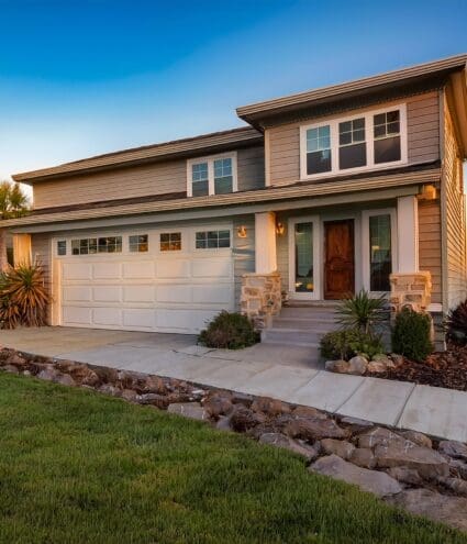 A home exterior with newly installed fiber cement siding in a light neutral color. J Kidd Construction