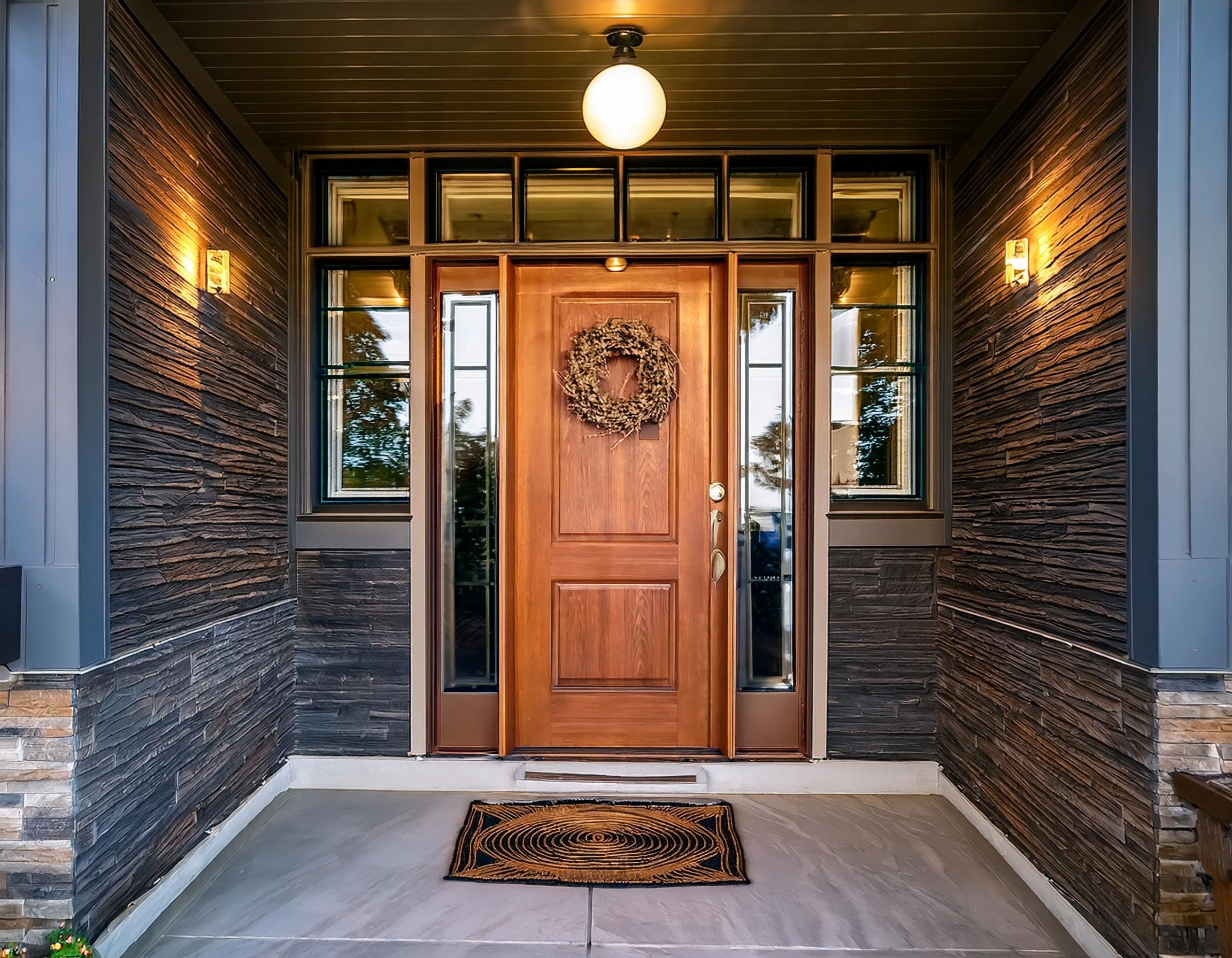 Close-up of a newly installed front door with modern hardware, natural light streaming in. J Kidd Construction